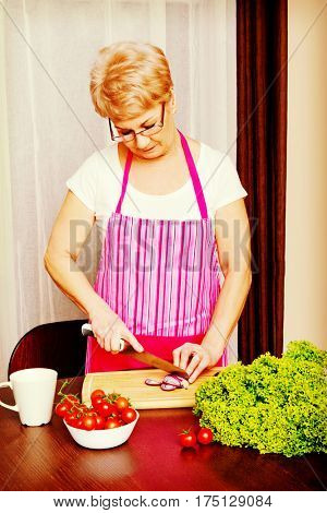 Woman cut red onion on cutting board