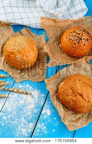 Assortment of multi-grain bread rolls on on blue wooden table. Home made bread.