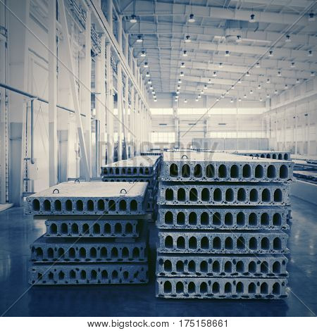 Stack of precast reinforced concrete slabs in a house-building factory workshop