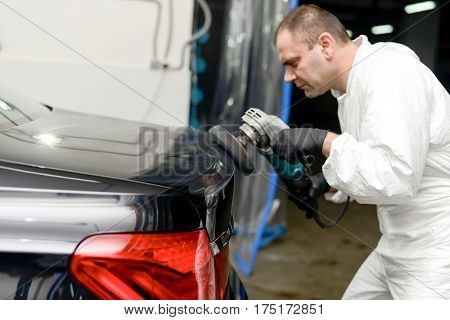 Man on a car wash polishing car with a polish machine