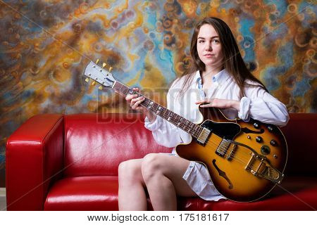 Podolsk, Russia - February 21, 2017: Young brunette girl with a vintage electric guitar Gibson es-345 1969 model year