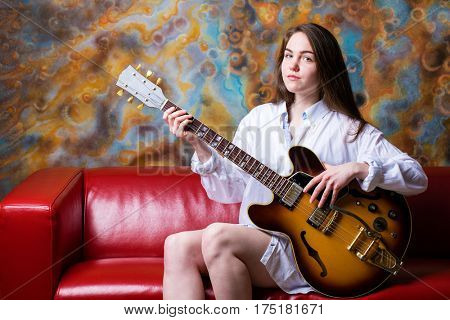 Podolsk, Russia - February 21, 2017: Young brunette girl with a vintage electric guitar Gibson es-345 1969 model year