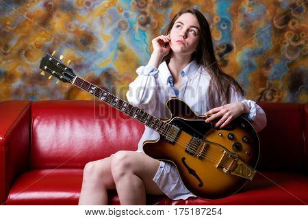 Podolsk, Russia - February 21, 2017: Young brunette girl with a vintage electric guitar Gibson es-345 1969 model year