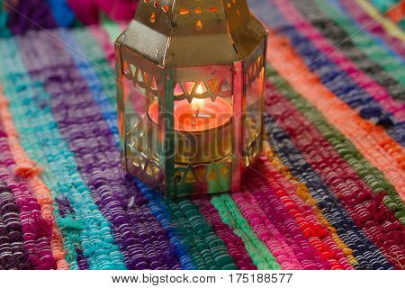 pink candle on a colorful handmade fabric .