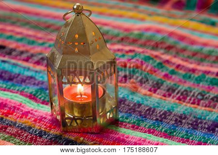 pink candle on a colorful handmade fabric .