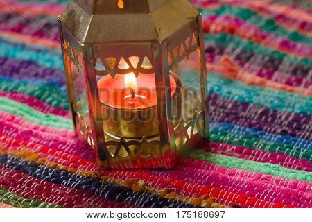 pink candle on a colorful handmade fabric .