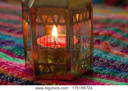 pink candle on a colorful handmade fabric .