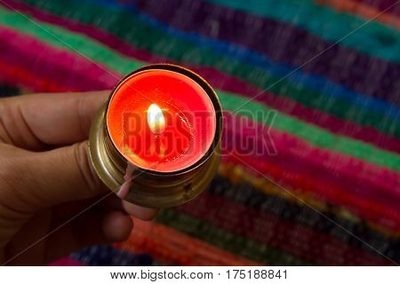 pink candle on a colorful handmade fabric .