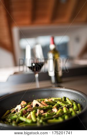 Fried green asparagus with mushrooms in a pan and short depth of field