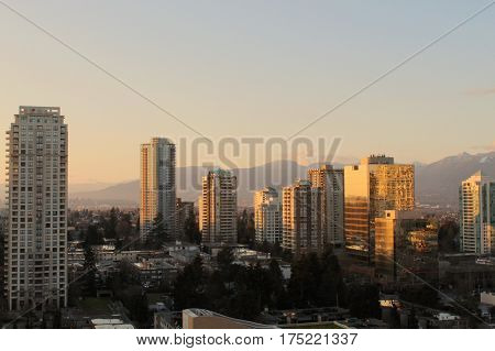 Cityscape And Mountains At Sunset