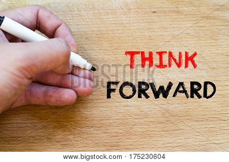 Human hand over wooden background and think forward text concept