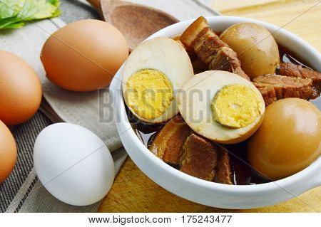 Eggs Stewed or Thai name is khai phalo muu saam chan on wooden background.