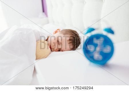Little Boy Child Sleeping In Bed. Hugging His Favourite Teddy Bear