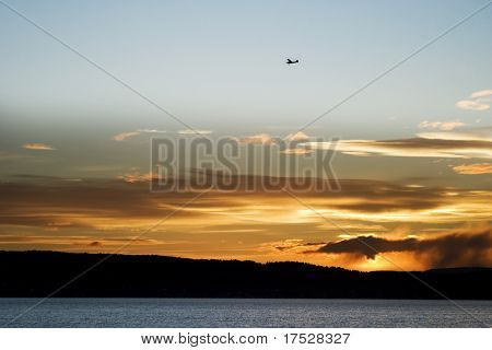 Самолет пролетел над Осло-фьорда во время заката.