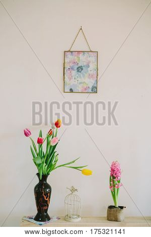 vase with tulips and candlesticks in white backgroud.interiror