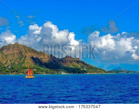 sailboat passing by diamondhead near waikiki beach