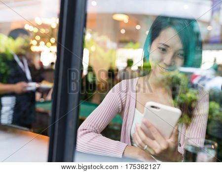 Woman using cellphone for online inside restauarant