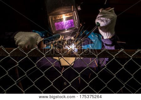 Workers are welding steel mesh in the work area.