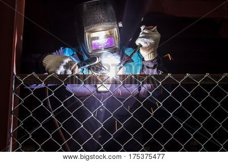 Workers are welding steel mesh in the work area.