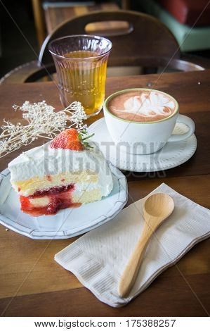 coffee cup and delicious cake strawberry and relax time moblie on table in coffee shop