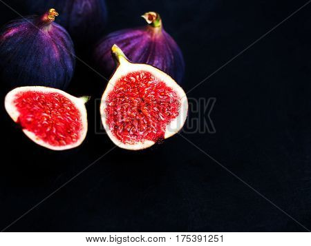 Ripe sweet figs on black background. Healthy Fresh fig fruit vivid colors.