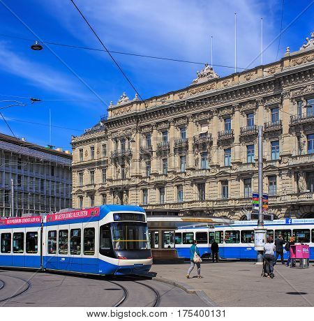 Zurich, Switzerland - 14 May, 2015: people, trams and buildings on Paradeplatz square, view from Bahnhofstrasse street. Paradeplatz is a square in the city of Zurich, one of the most expensive pieces of real estate in Switzerland.