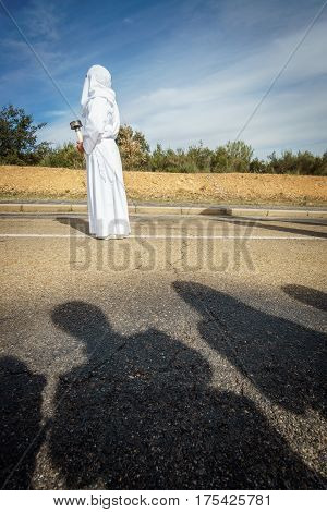 Tourist shadows enjoying easter traditional procession in bercianos de aliste brotherhood, zamora, Spain