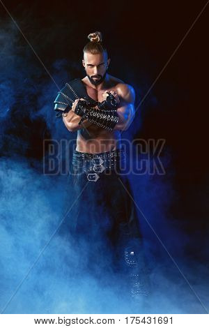 Young and muscular man performing a theatrical pose on stage. Striptease. Handsome man