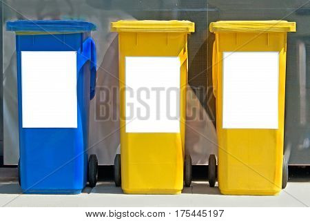 Three colorful plastic trash cans on street