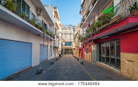 Vacant & shaded, empty alleyway on otherwise bright sunlit day in Sant Antoni De Portmany.  Ibiza in quiet off-season in the afternoon.