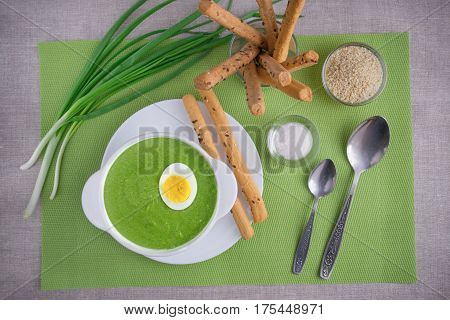 Spinach cream soup with egg and breadsticks