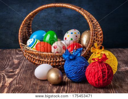Colorful easter edds in basket on a brown wooden table
