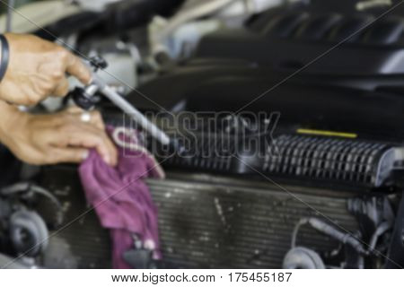 Blurry image Man was cleaning and wiping car radiator fin and car engine with Hand and Violet Microfiber Cloth and Air gun. Air pressure Car cleaning Car Washing