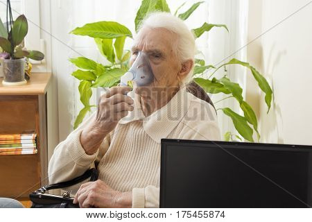 The old woman during inhaltion. The patient keeps inhaler.