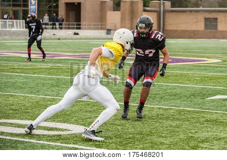 Football cornerback keeping eyes on the wide receiver.