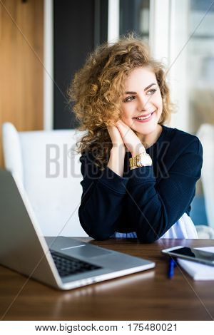 Young Attractive Woman At A Modern Office Desk, Working With Laptop, Looking At The Window, Thinking