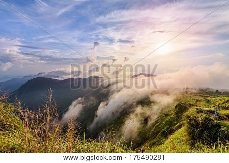 Beautiful landscape nature on peak mountain with sun cloud fog and bright colors of sky and sunlight during sunset in winter at viewpoint Phu Chi Fa Forest Park in Chiang Rai Province Thailand