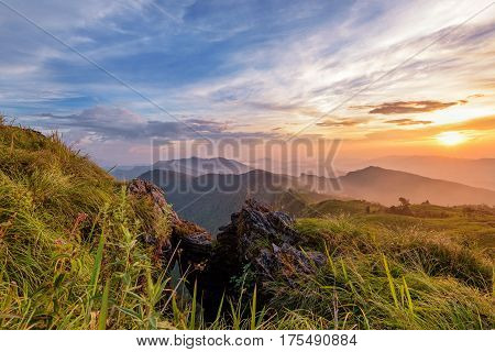 Beautiful landscape nature on peak mountain with sun cloud fog and bright colors of sky and sunlight during sunset in winter at viewpoint Phu Chi Fa Forest Park in Chiang Rai Province Thailand