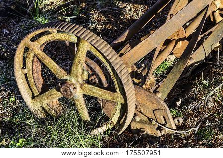 Old rusted manual push lawn mower closeup of metal wheel and blades antique
