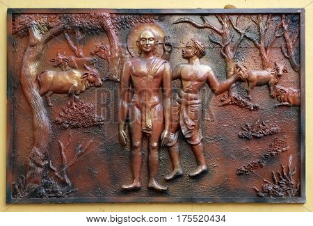 KOLKATA, INDIA - FEBRUARY 09, 2016: Bhagavan Mahaviras ears plugged with neddle - like wooden pegs, Street bass relief on the wall of Jain Temple (also called Parshwanath Temple) in Kolkata, India 
