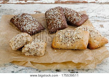 variety of small breads with seeds on grille
