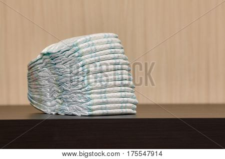 Stack of diapers or nappies on table with copyspace closeup