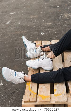 Legs and feet of couple in love in stylish white snickers