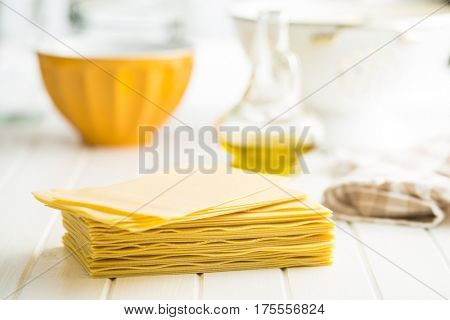 Raw lasagne sheets on white table.