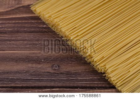 Uncooked spaghetti lie on a diagonal direction, close up