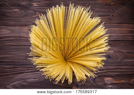 Yellow long spaghetti on a rustic background, top view
