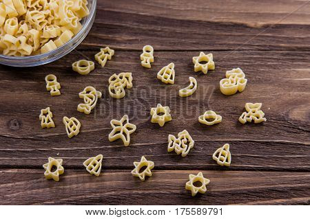 Raw macaroni on an old wooden table. Mix pasta. Background