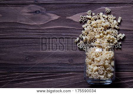 Raw macaroni on an old wooden table. Mix pasta. Background