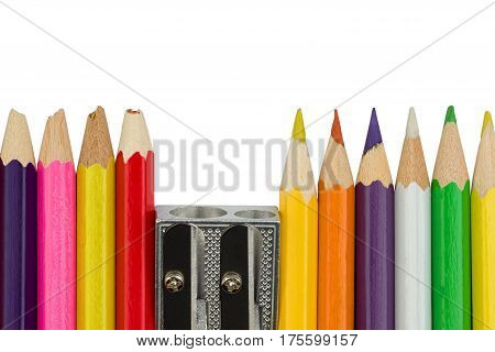 Blunt and sharp colored pencils with sharpener are standing in a row