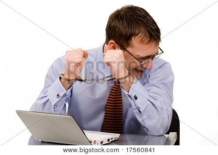 Bonito jovem empresário ligado ao laptop com algemas